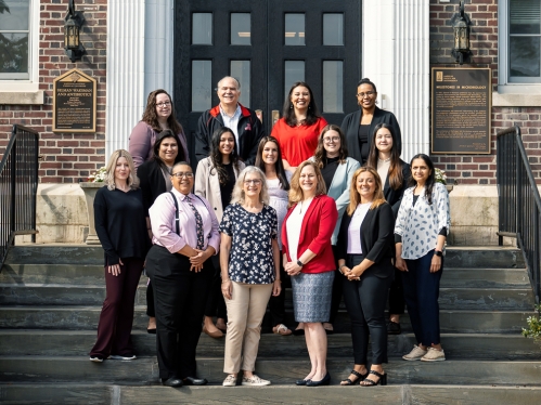 The Office of Academic Programs staff standing on the steps in front of Martin Hall.